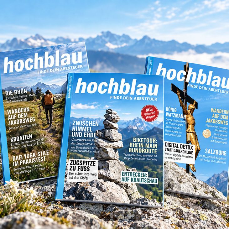 Mehrere Ausgaben des hochblau Magazins vor einer alpinen Berglandschaft.